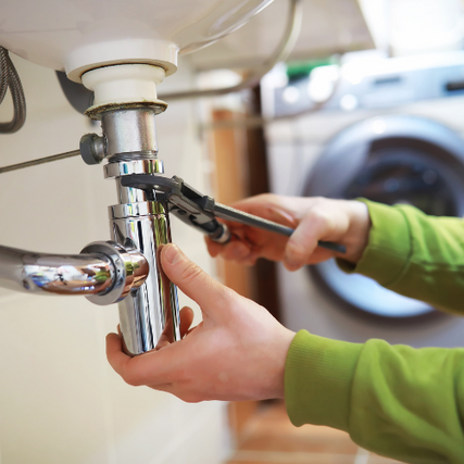 Plumbing & SuppliesA wrench tightening a pipe underneath a sink