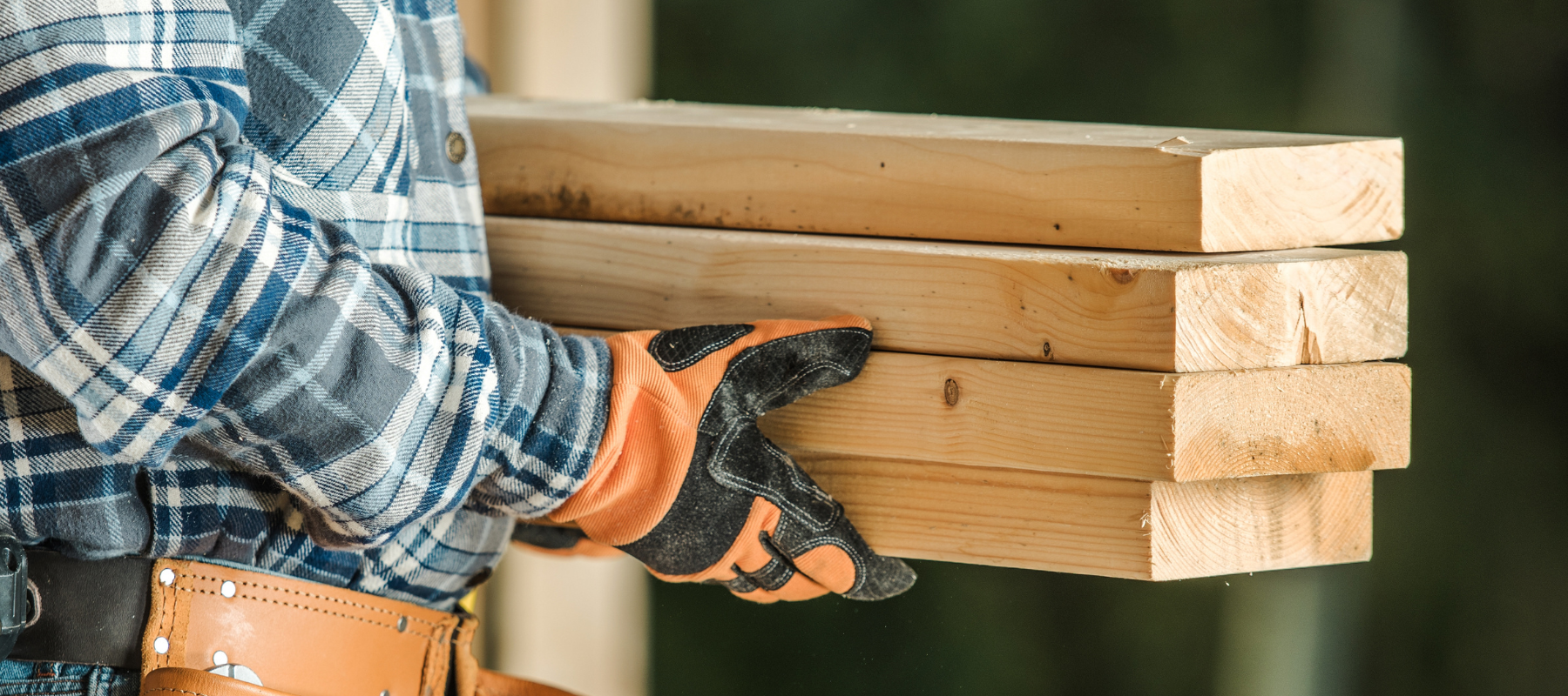 A contractor carrying lumber